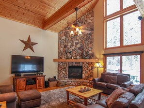 Spacious vaulted living room with plenty of seating, floor to ceiling windows