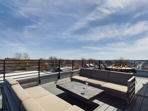 Unit 1: Private 4th-story balcony featuring outdoor furnishings for lounging and dining offering neighborhood and city views.