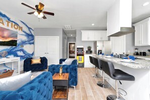 MelaNation! Living Room with cozy couch and 75 inch TV