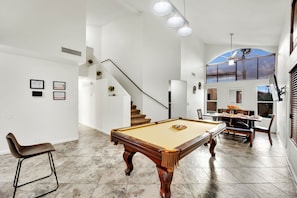 As you step into this exquisite vacation rental, you're greeted by a charming vintage pool table, inviting even the most discerning pool shark to showcase their skills.