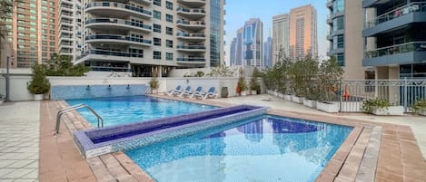 Pool Oasis: Dive into tranquility surrounded by stunning city views and sleek lounge chairs!