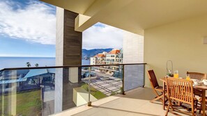 Indulge in serenity at Sunset Bay, Ponta da Cruz, Funchal. A spacious balcony offers ocean serenity, glimpses of mountains, and a delightful outdoor breakfast setup. #funchal #oceanview #mountainview #balcony #relaxing