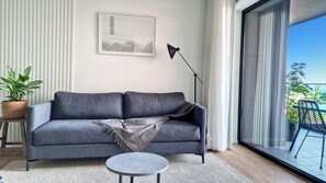 Lounge in luxury on our plush sofa at Roots Loft—a haven of comfort with a front-row seat to the stunning balcony views, creating a perfect retreat that can be converted into a sofabed #modern #beautifulapartment