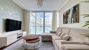 Luxuriate yourself on the expansive sofa in the living room while immersing yourself in entertainment on the state-of-the-art SMART TV. #apartment #lavie #heartoffunchal