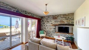 An indoor cozy living room adorned with warmed lighting. #livingroom #cozy #tv #patio #oceanview