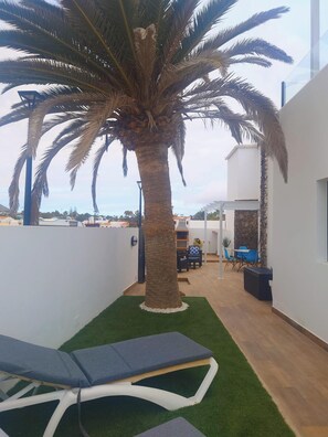 Front veranda sunbathing area with external staircase leading up to the roof ter