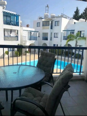 pool view with outside balcony table and 4 chairs