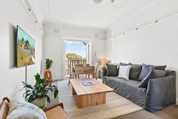 The living room beckons you to relax with its calming colour pallette and charcoal grey linen lounge. 