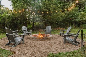 NEW fire pit area with hanging lights and Adirondack chairs!