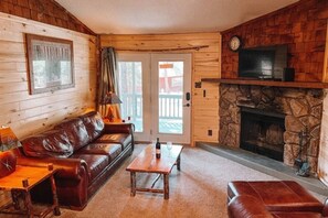 Modern & rusting central living area with a fireplace and smart TV. Smart TV provides access to streaming networks like Netflix, Amazon Prime, Hulu and more.