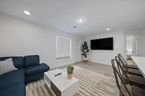 Living room with comfortable couch & Big screen smart TV