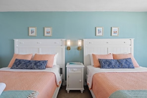 Drift off to sleep in these plush double beds, dressed in soft, inviting linens with a fresh coastal color palette. Thoughtfully designed with modern lighting and charming decor, this space is