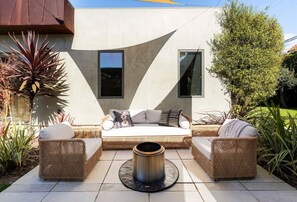 Cozy up by the fire and soak in the sunshine in this inviting outdoor retreat.