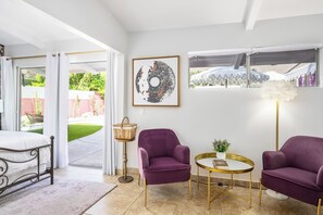 Unwind in this tranquil bedroom retreat. Enjoy the soft natural light, plush seating, and easy access to the private outdoor space. Perfect for a peaceful getaway.