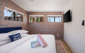 Stylish room with vibrant decor, plush bedding, and sunny views—perfect for relaxation!