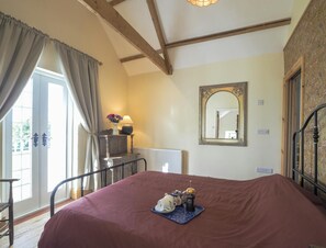 Kingsize bed with breakfast tray on it. Wall mounted mirror
