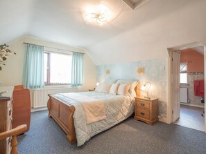 Driftwood master bedroom with pale blue bedding, bedside tables, chest of drawers and window