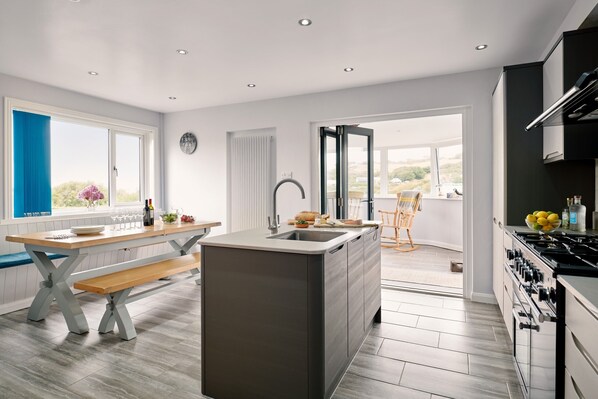 Open plan kitchen and dining area, with bifolding doors through to sun lounge