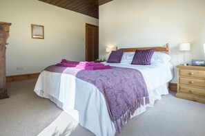 Double bed with towels at the foot of the bed, bedside cabinets and lamps