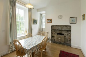 Dining room with table and chairs, fireplace and two windows
