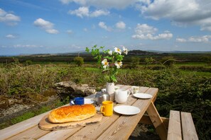 Picnic bench with picnic foods and a view over the surrounding countryside