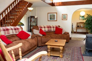 Two large sofas with red cushions and throws