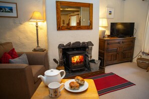 Sitting room with log burner, armchair and coffee table