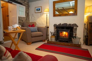 Lounge with fireplace and woodburner, armchair, coffee tray