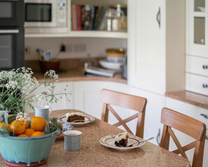 Kitchen island with breakfast bar and two chairs, fruit bowl