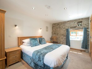 King size bed in the master bedroom at Eirlys, bedside cabinets, wardrobe, chair and window