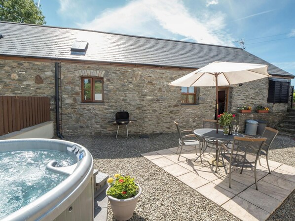 Patio area with table and chairs and hot tub