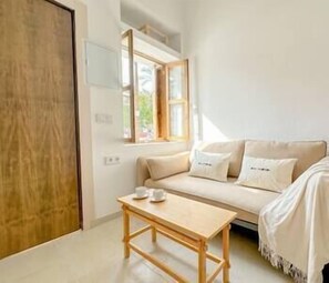 Cozy living room with double sofa bed, coffee table and window with beautiful view. (2)