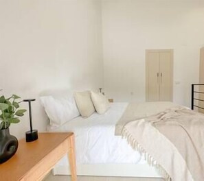 Bright master bedroom with double bed, two bedside tables and storage area. (2)