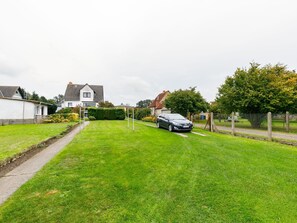 Plant, Sky, Car, Vehicle, Land Lot, Natural Landscape, Grass, Asphalt, Road Surface, Tree