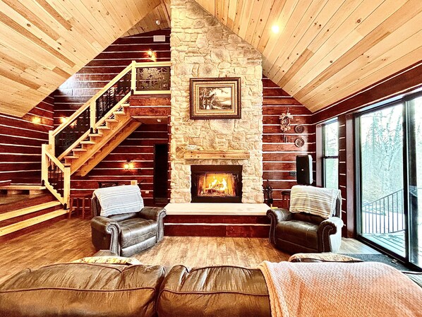 Open concept, family sitting area with large stone woodburning fireplace
