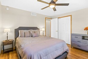 Main floor bedroom with queen bed and ceiling fan