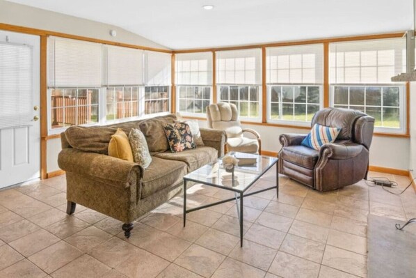 Light filled sunroom for coffee, cocktails, with walkout to deck and backyard.