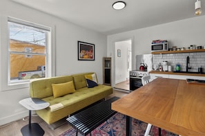 Cozy and modern open-concept living space with a stylish sofa and fully equipped kitchen.
