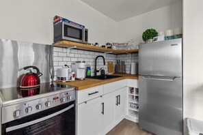 Fully equipped modern kitchen with stainless steel appliances and stylish subway tiles.
