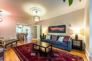 Living Room: Cozy living area with restored original flooring.
