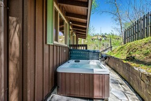 The private outdoor space includes a hot tub, charcoal grill and patio area.