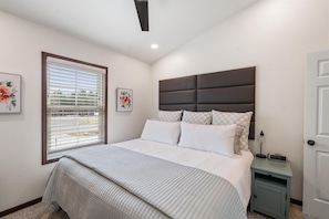 Bedroom with King Bed and TV, Bathroom located around the corner in hallway.