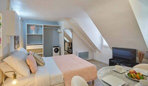Studio avec lit queen size, cuisine ouverte et tv