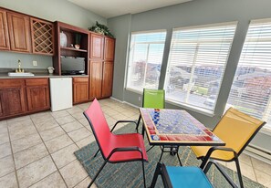 Enclosed sunroom with full bar, sink, refrigerator, TV, and gorgeous view!