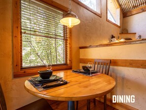Enjoy intimate meals at Bear's Den's cozy dining nook, where natural light filters through the windows, creating a warm and inviting atmosphere—perfect for starting your day or winding down in