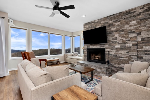 Large living room with plenty of seating, 65" Roku HDTV, and cozy fireplace.