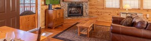 Step inside Hidden Haven's inviting living area, where rustic charm meets modern comfort. Relax by the cozy fireplace and watch your favorite shows on the TV complete with Roku. This charming