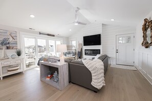 Bright Coastal Living Room with Fireplace and Balcony Access