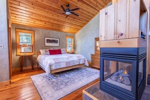 Embrace coziness in our inviting bed space, complemented by a mirror and the soothing warmth of the indoor fireplace, creating a tranquil retreat for rest and relaxation.