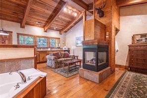 Unwind in style: Living area ambiance meets hot tub luxury by the fireplace glow.
